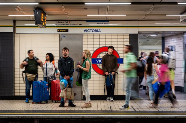 People waiting on the platform of Victoria London Underground station.