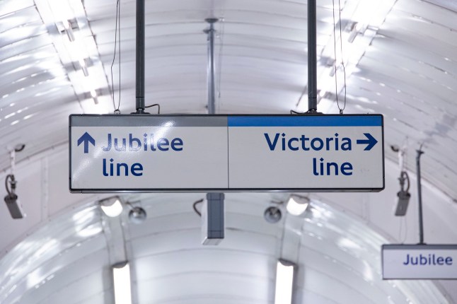 London underground subway train station with Jubilee Line and Victoria Line at Green Park station in Mayfair, city of Westminster in London, England, UK. General view of the interior of the station with the moving escalator, train wagon and Underground Sign Logo at the platform, while people are waiting in the station or are seen inside the rail carriage commuting, some of them wearing a facemask because of Covid-19 Coronavirus Pandemic or others are on their phones. London, UK on August 2022 (Photo by Nicolas Economou/NurPhoto via Getty Images)