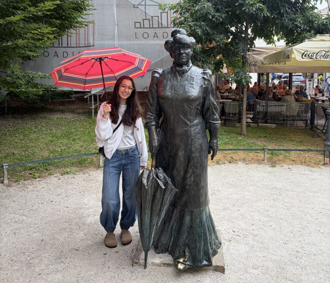 Isabel Fraser standing next to the Marija Jurić Zagorka statue in Zagreb, Croatia.
